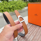 Orange-brown leather belt held up, showing silver buckle and dark inner lining