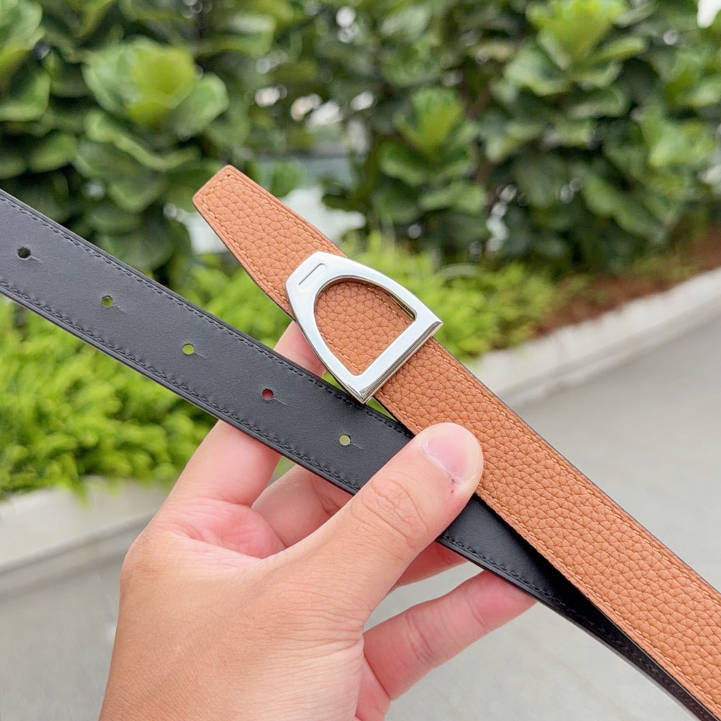 Leather belt with orange-brown strap and silver buckle over dark gray belt strap