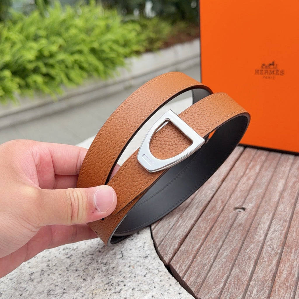 Leather belt close-up with orange-brown strap and silver D-ring buckle