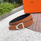Orange-brown leather belt with silver buckle, curved edge, and dark underside