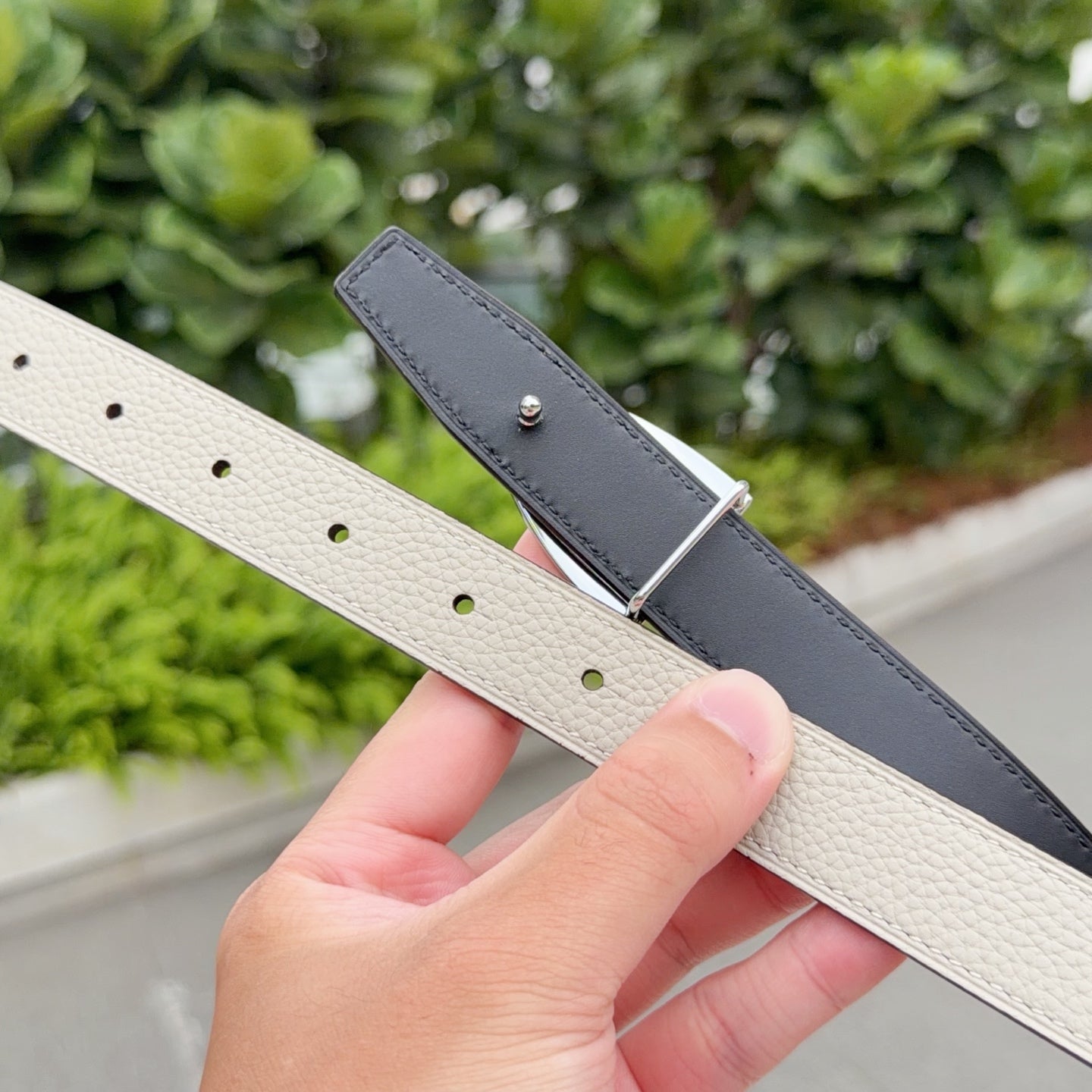 Reversible leather belt straps in light beige and dark gray with silver buckle