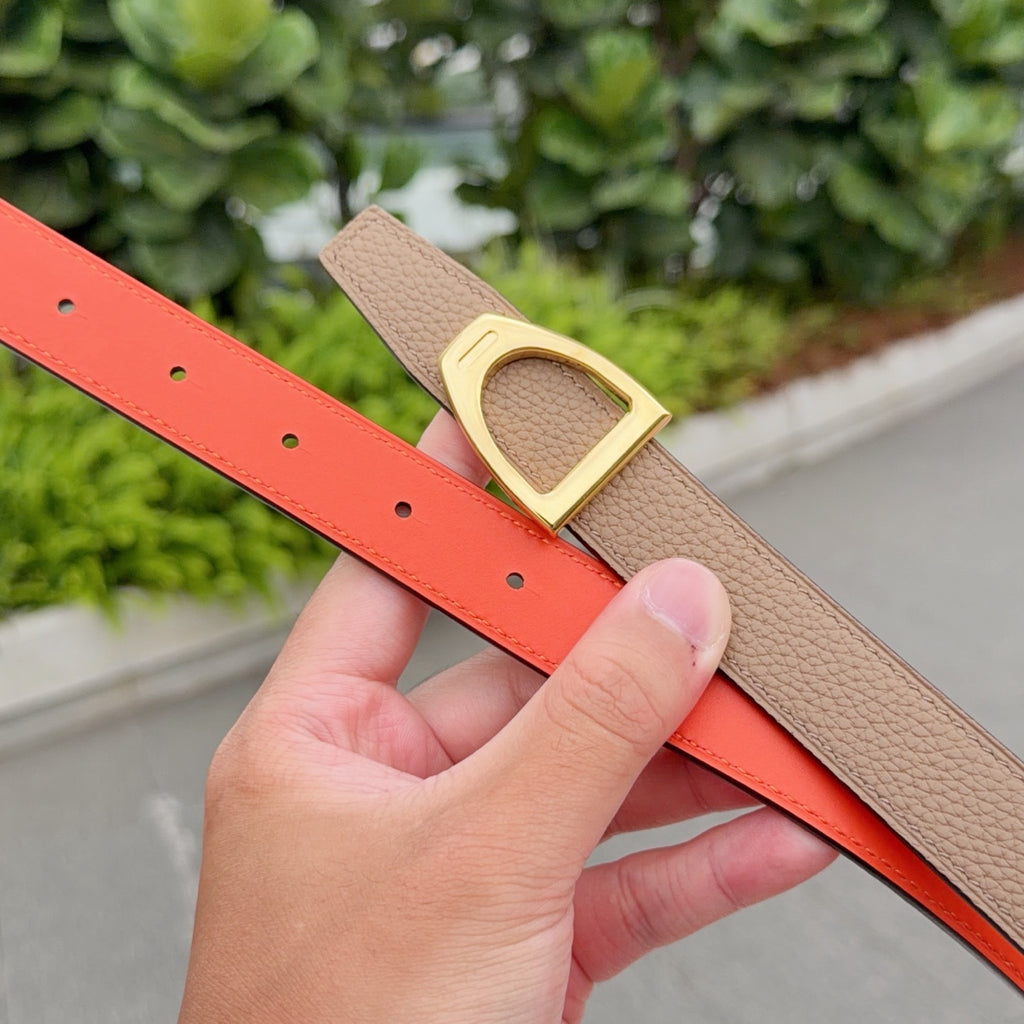 Tan leather belt with gold buckle and bright orange underside, with punched holes