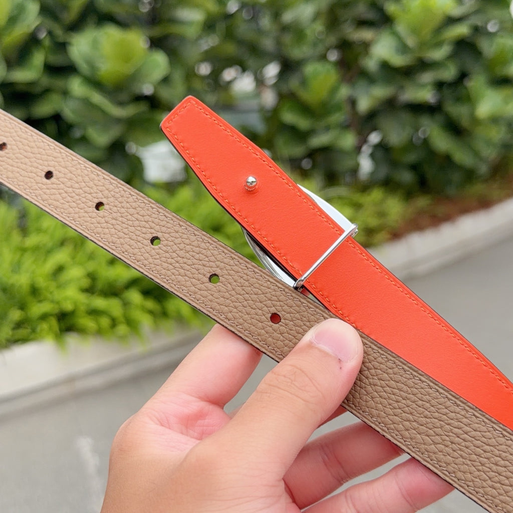 Tan and orange leather belt with silver buckle and perforated holes