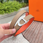 Brown leather belt with silver buckle and orange underside