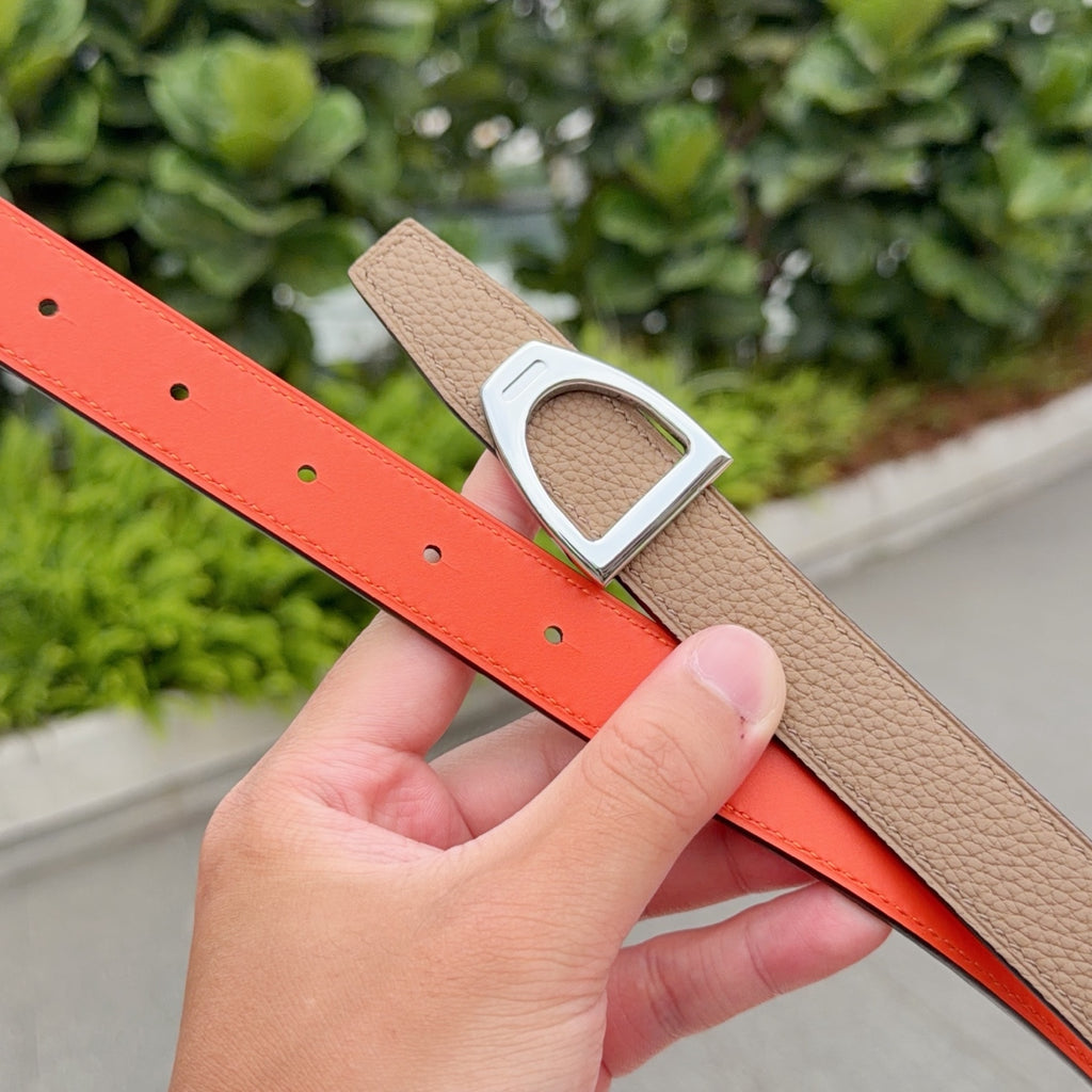 Orange leather belt strap with silver buckle over brown side