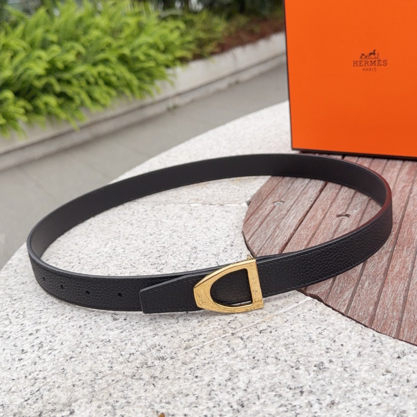 Black leather belt with gold-tone rectangular buckle and punched holes