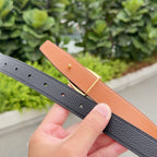 Leather belt close-up: black strap with pin holes and tan leather underside