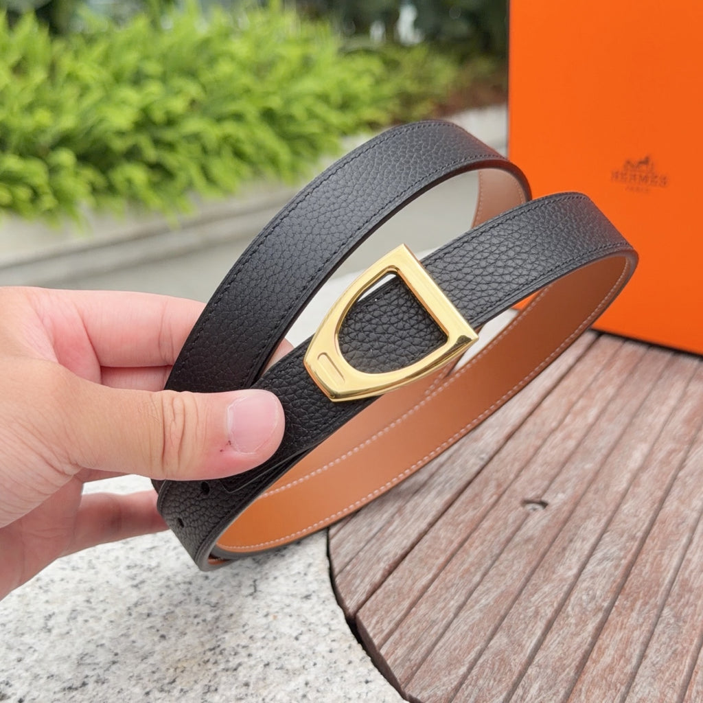 Leather belt detail: black textured strap with gold buckle and tan underside
