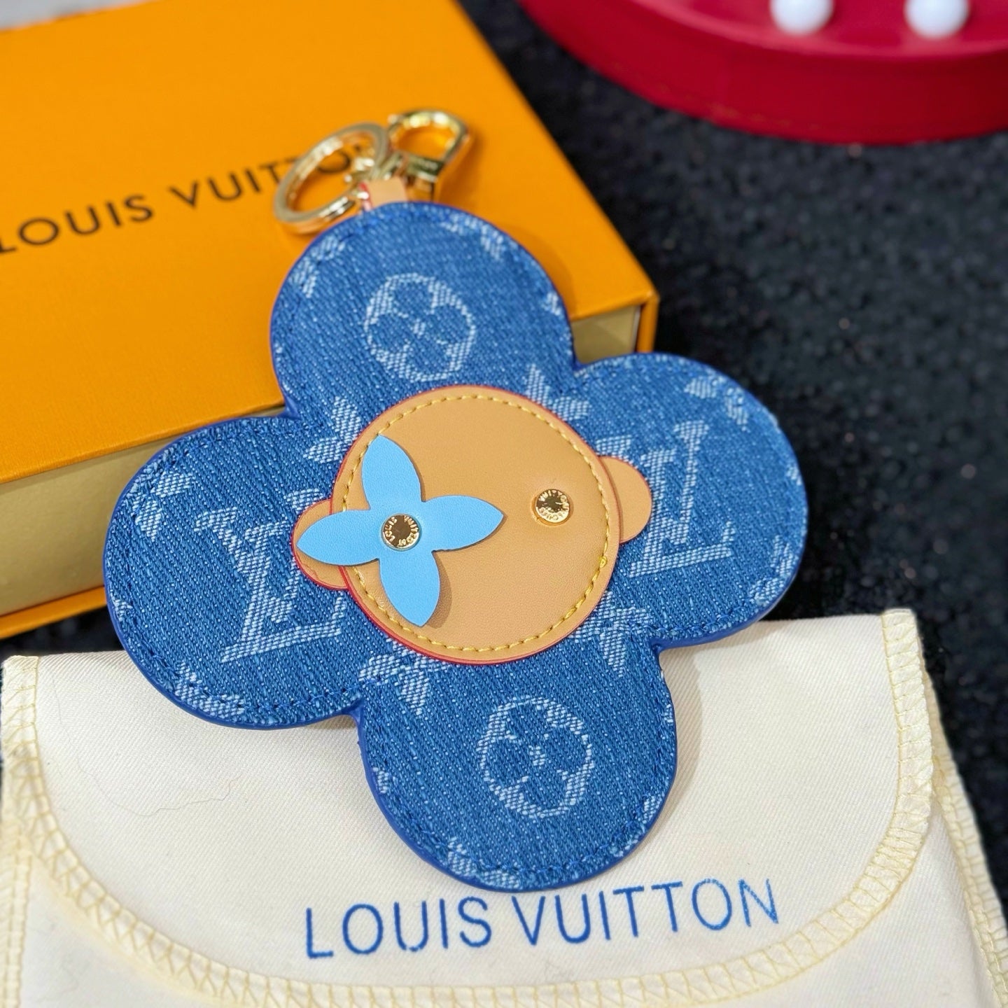 Louis Vuitton blue flower keychain charm with beige emblem center and metal hardware