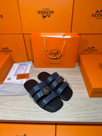 Pair of dark blue leather slide sandals with adjustable buckled straps