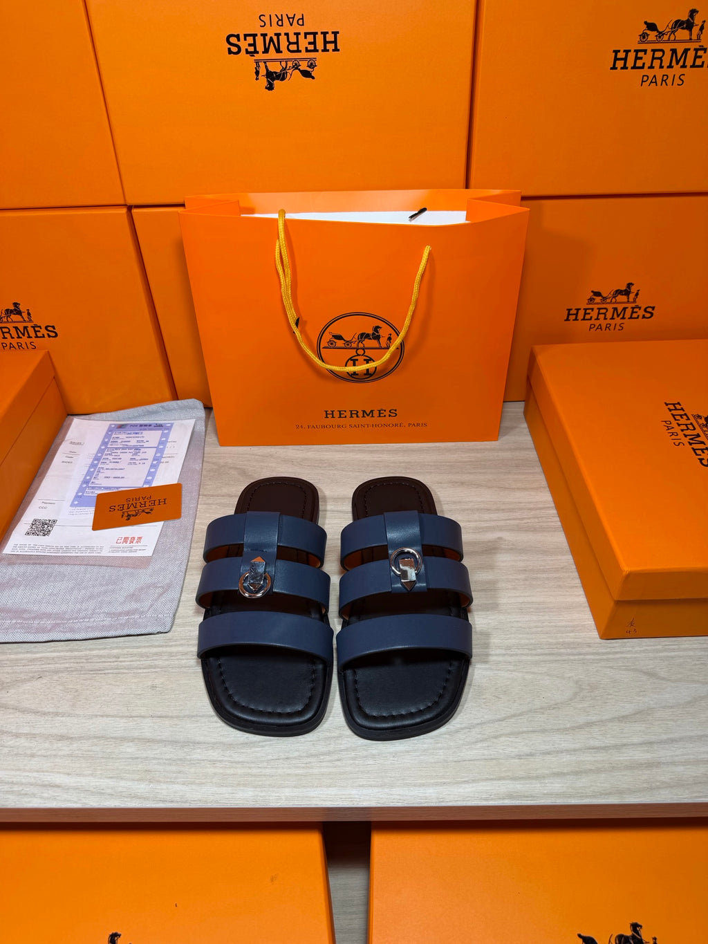 Leather slide sandals with dark blue striped straps and metal buckles