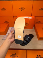 Back view of dark blue leather slide sandal outsole with tread pattern