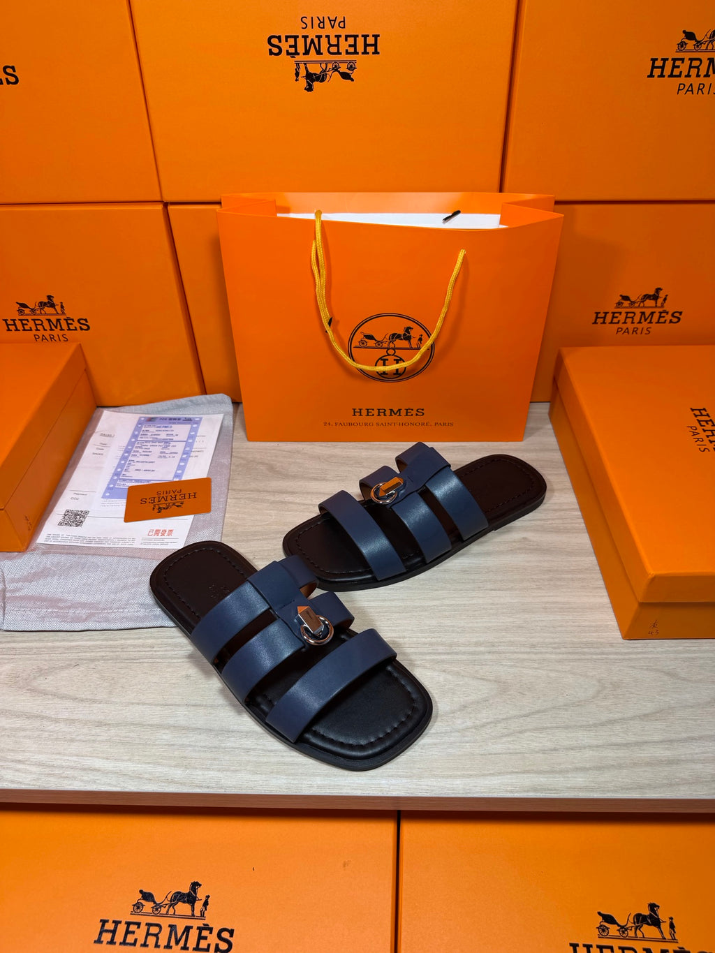 Dark blue leather slide sandals with crossed strap bands and metal buckle details