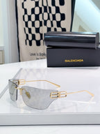 Balenciaga glasses with clear lenses and gold-tone frame with embossed accents