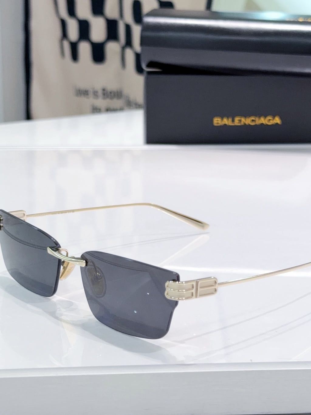 Gold-tone sunglasses with dark lenses and metal temple hinge detail