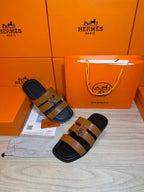 Hermes leather sandals with tan straps and silver buckle, dark sole and footbed.