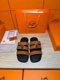 Hermes leather sandals with tan straps and silver buckle, dark footbed.