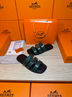 Hermes green leather slide sandals with two wide straps and silver buckle detail