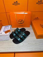 Hermes green leather slide sandals with two wide straps and silver buckle hardware