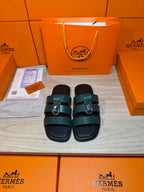 Hermes green leather slide sandals with two wide straps and silver buckle hardware