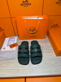 Teal leather slide sandals with two wide straps and silver buckle, flat sole