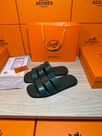 Pair of teal leather slide sandals with double straps and silver buckle detail