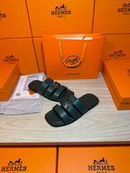 Teal leather slide sandals with double straps and silver buckle, shown from above