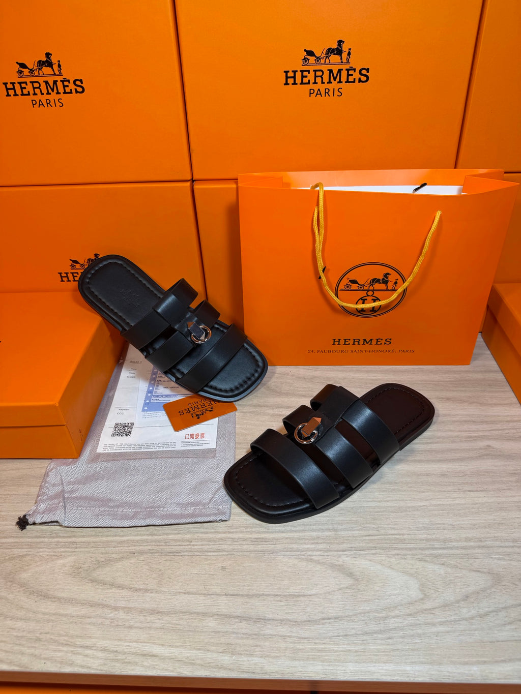 Pair of dark leather Hermes slide sandals with two top straps and metal buckle