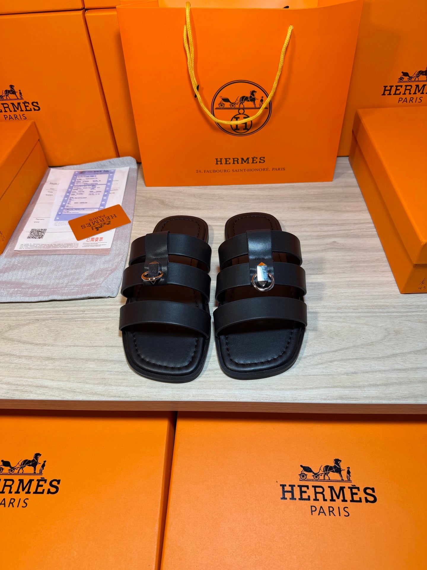 Hermes leather slide sandals with two dark wide straps and metal buckle detail