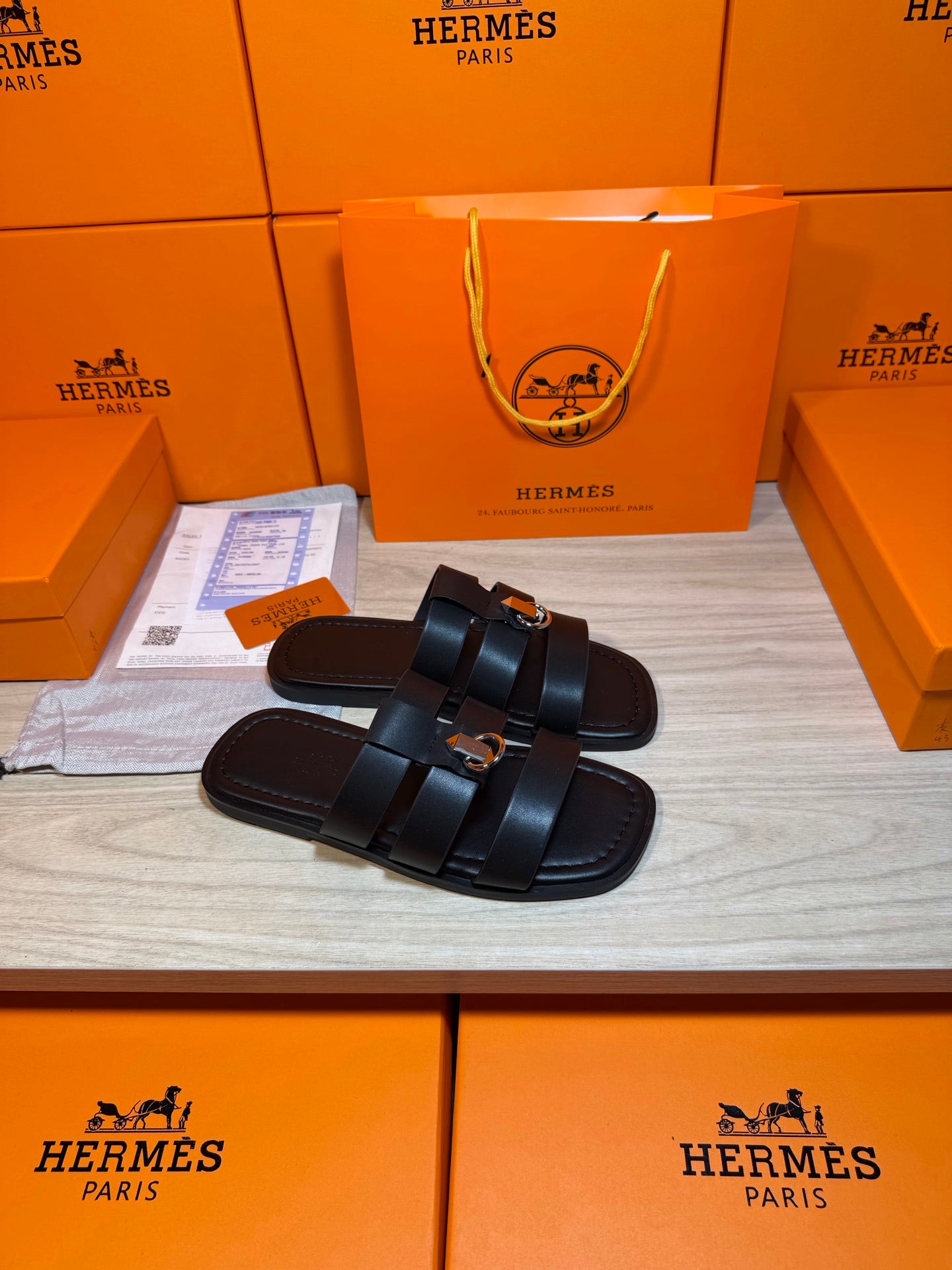 Hermes leather slide sandals, two dark straps across the top with metal buckle