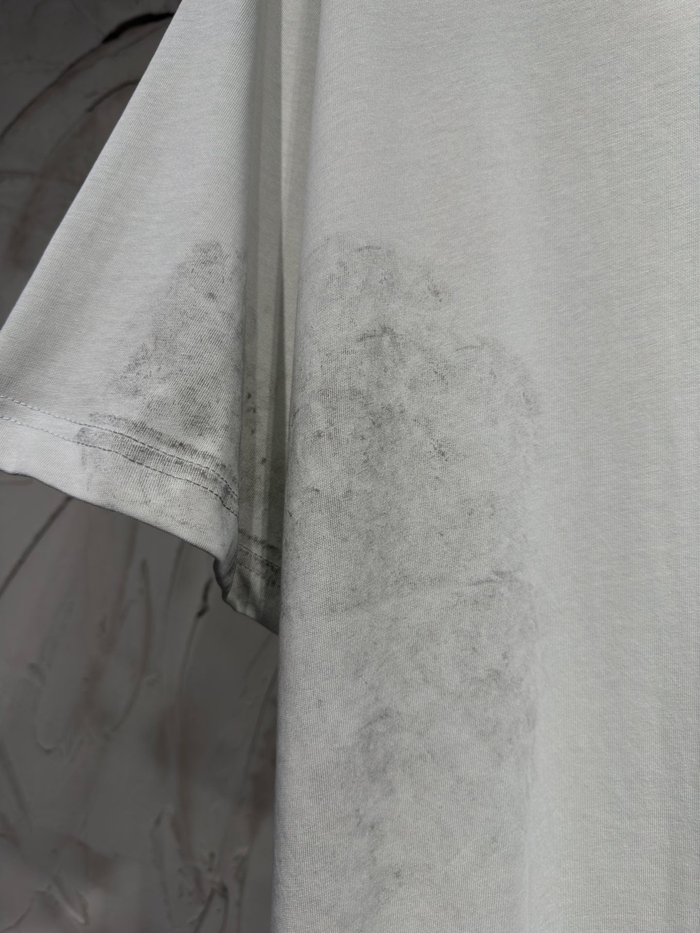 Balenciaga T-shirt, light gray fabric close-up with stitched hem and sleeve