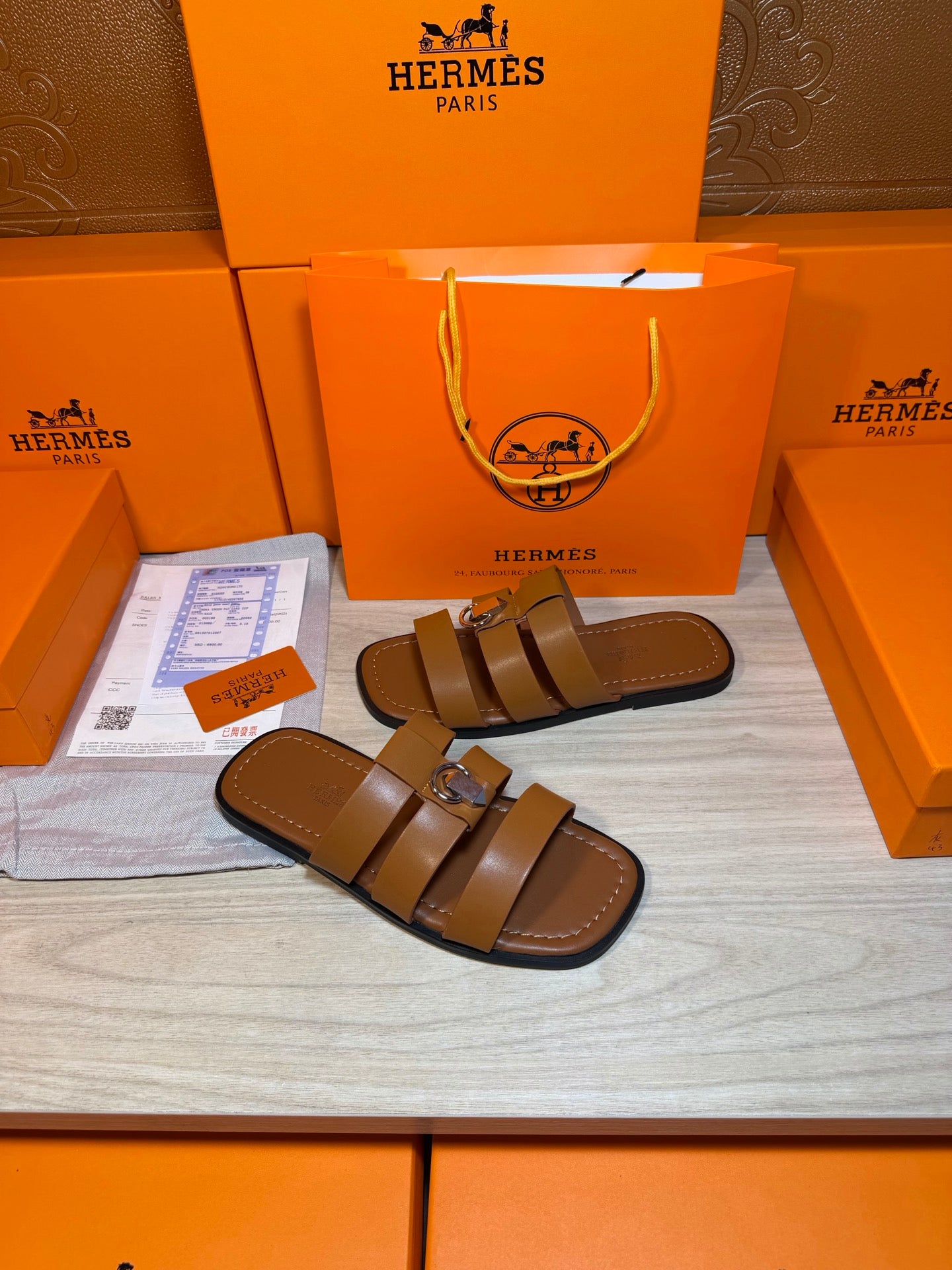 Brown leather sandals with two straps and silver buckle, pair on display.