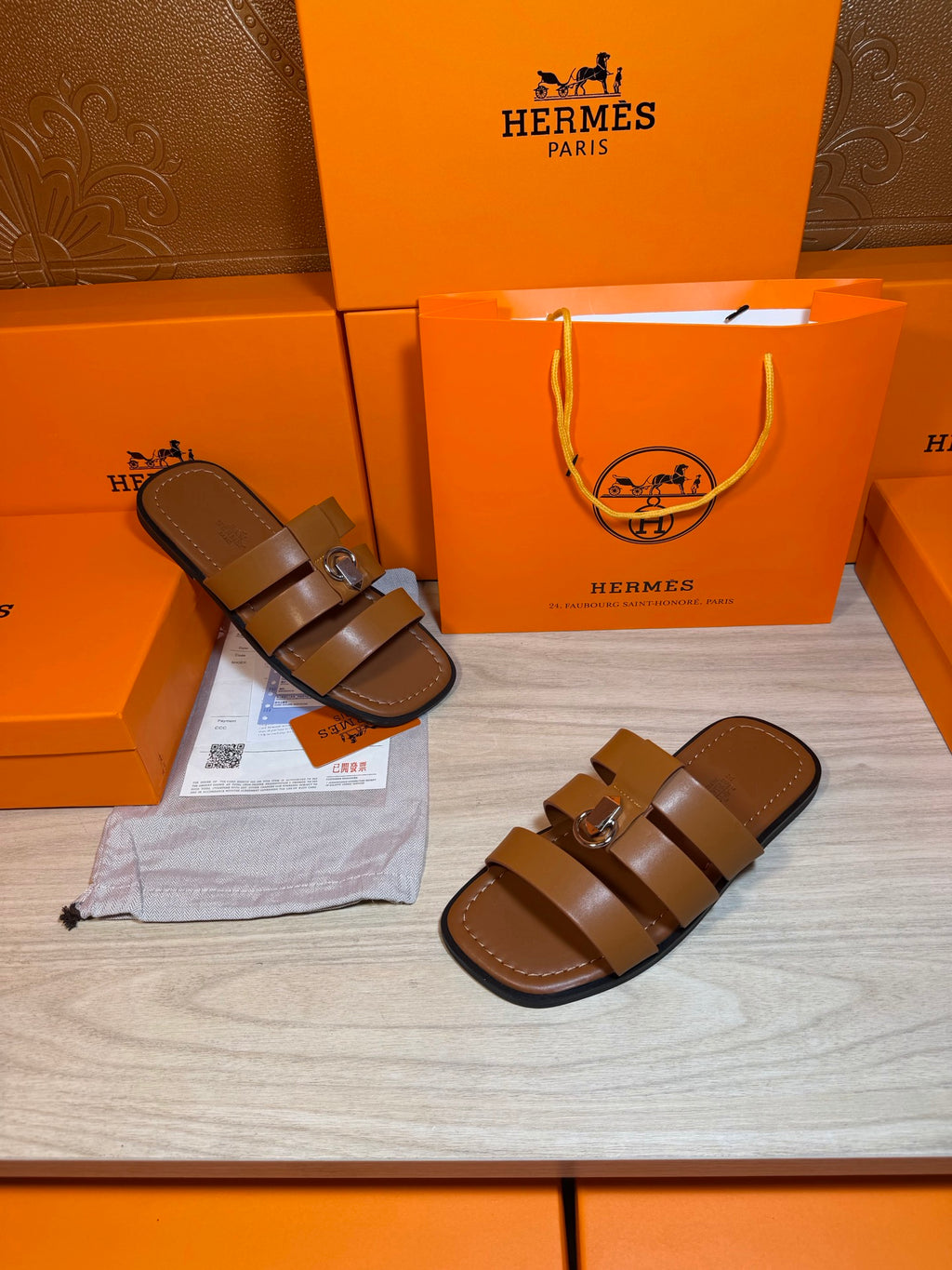 Brown leather sandals with two wide straps and silver buckle, single and pair.
