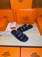 Dark blue leather slide sandals with two straps and a metal buckle at the top