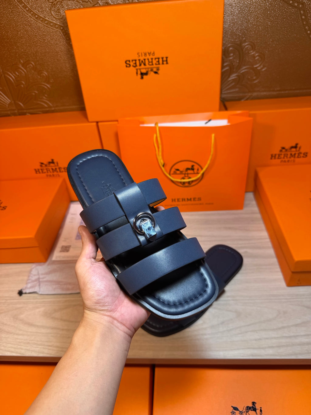 Dark blue slide sandal held up: two straps with a metal buckle across the top
