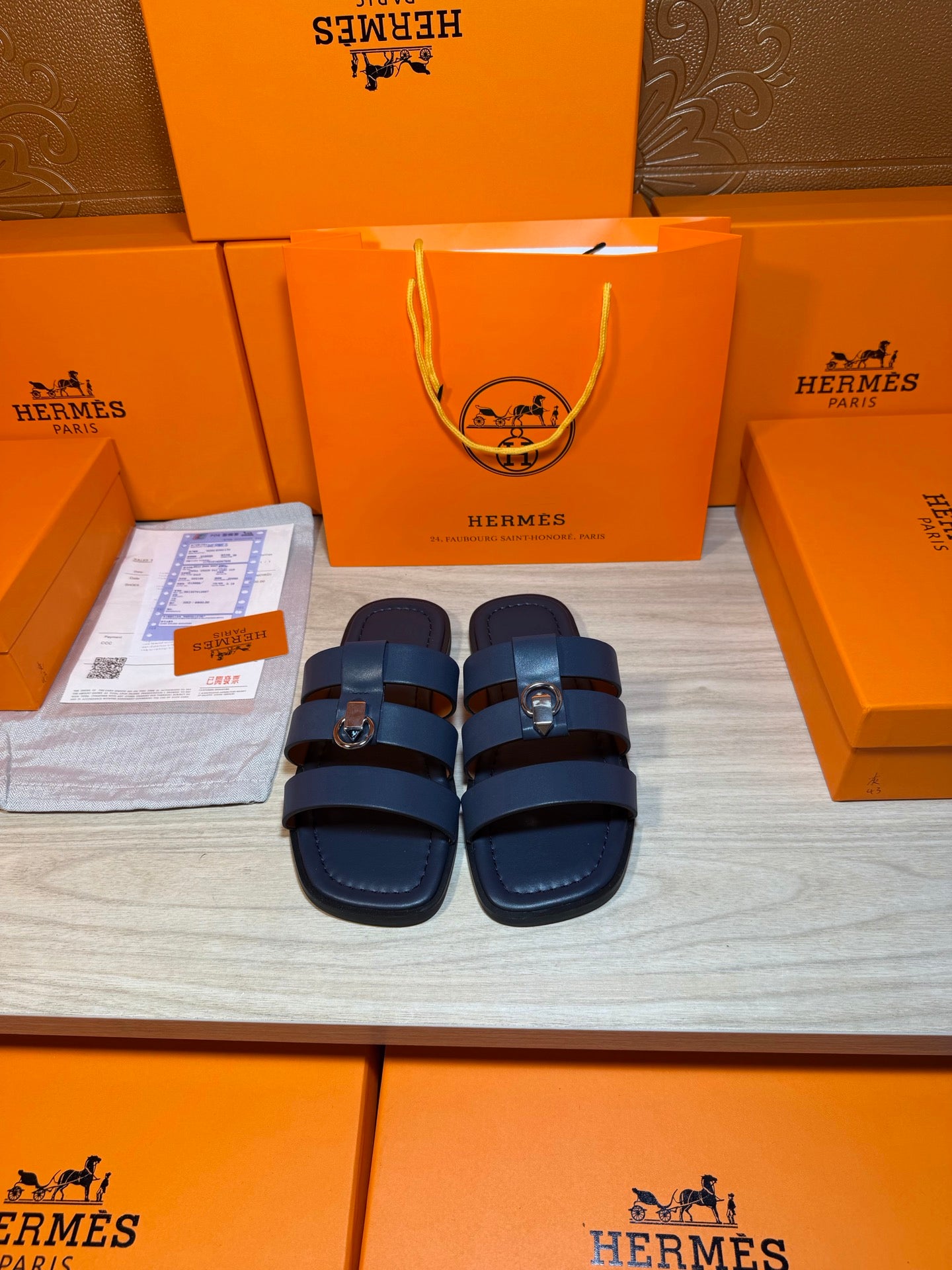 Dark blue leather slide sandals with two adjustable straps and metal buckle