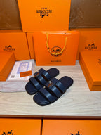 Dark blue slide sandals with two wide straps and round metal buckles