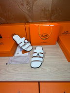 Hermes white leather slide sandals, close side view with double straps and silver buckle
