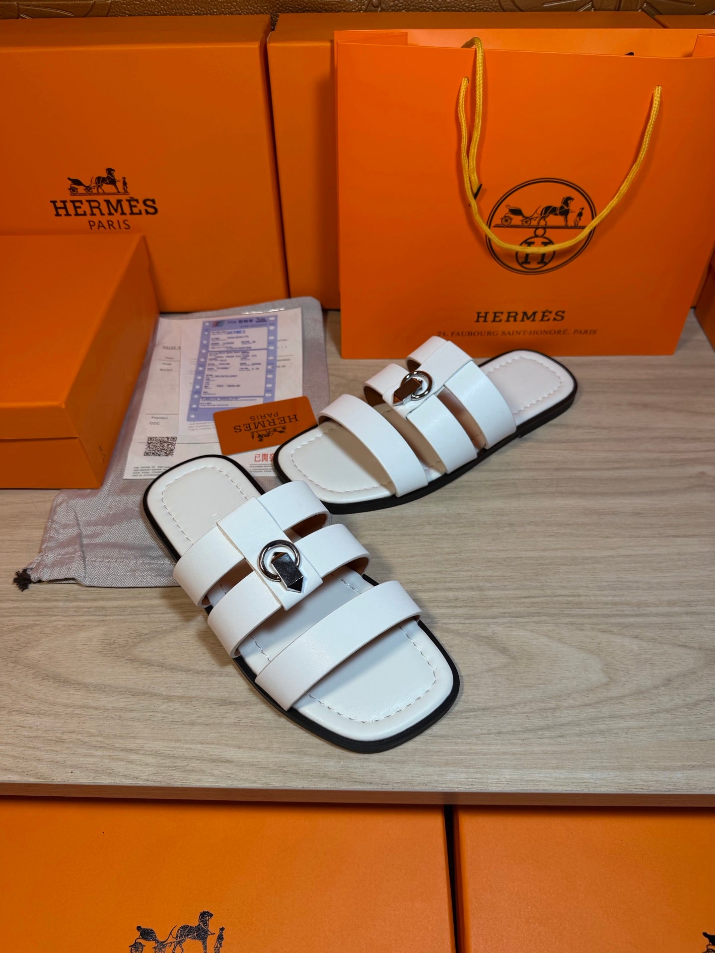 Hermes white leather sandals pair on display with double straps and metal buckle