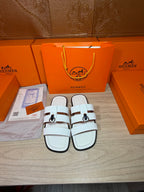 Hermes white leather slide sandals with double straps and silver buckle