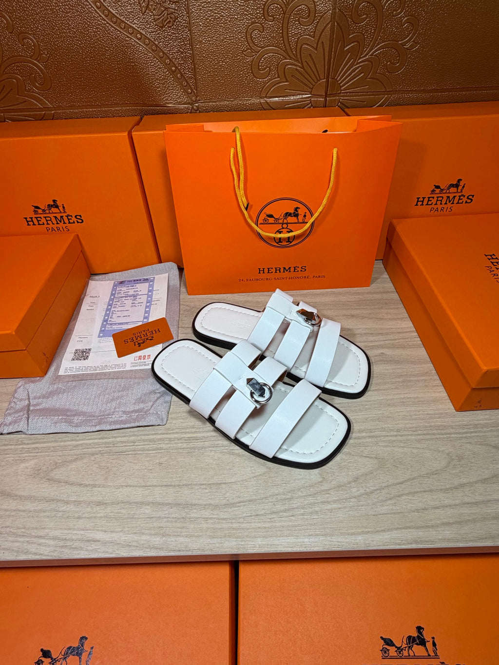 Hermes white leather slide sandals, angled view with double straps and round buckle