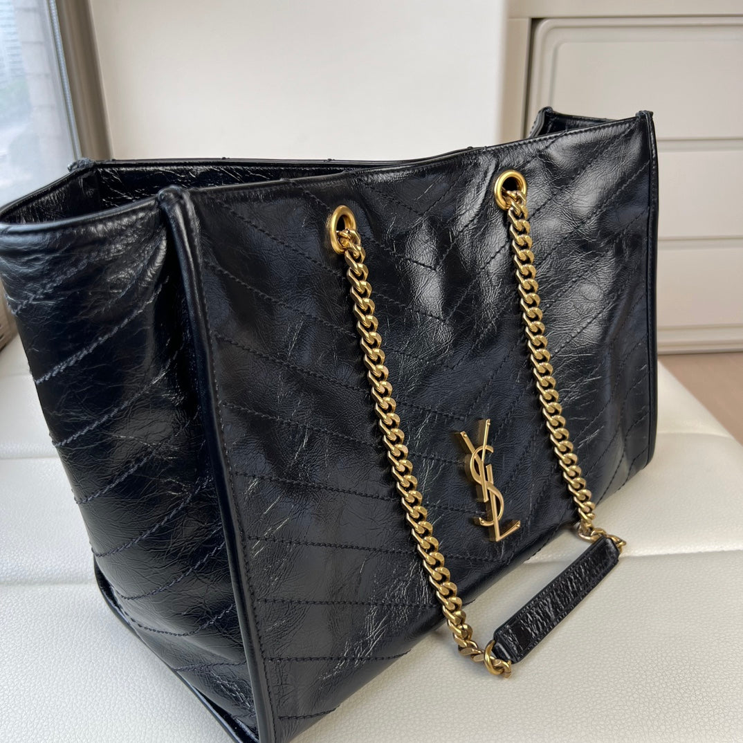 YSL quilted leather tote bag with gold chain straps, YSL logo, and side tassel