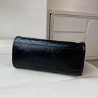Black leather tote bag back view with quilted texture and top border