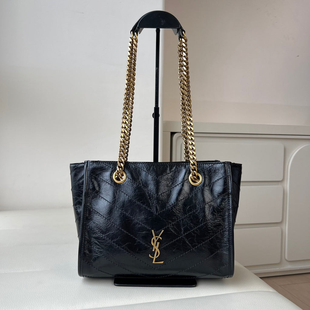 Black quilted leather tote bag with gold YSL emblem and chain shoulder handles