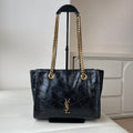 Black quilted leather tote bag with gold YSL emblem and chain shoulder handles