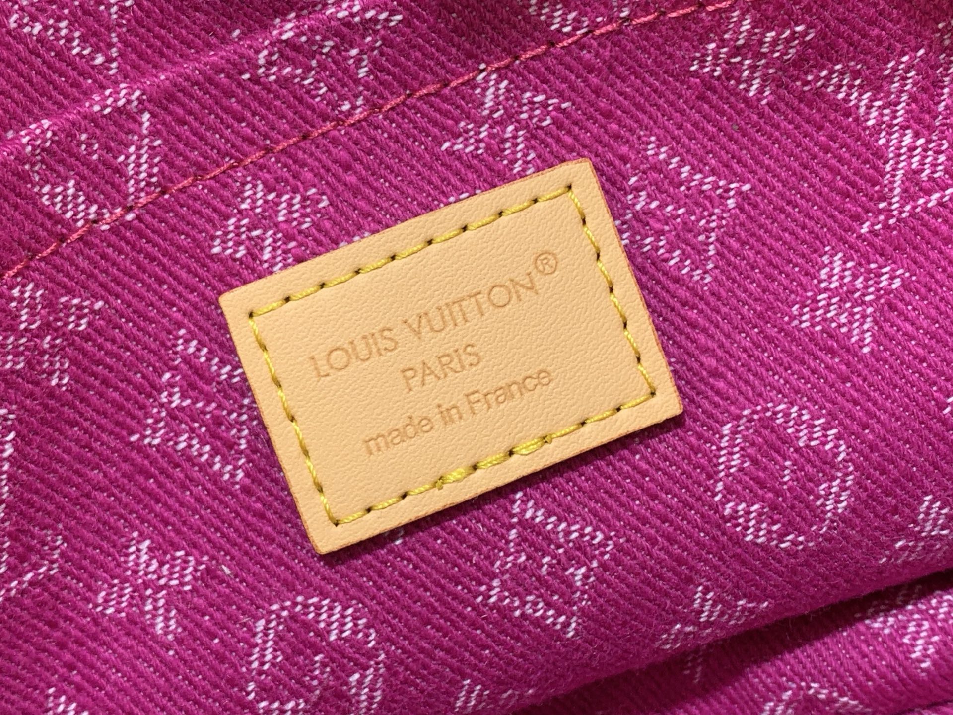 Louis Vuitton fuchsia monogram bag label on stitched leather patch