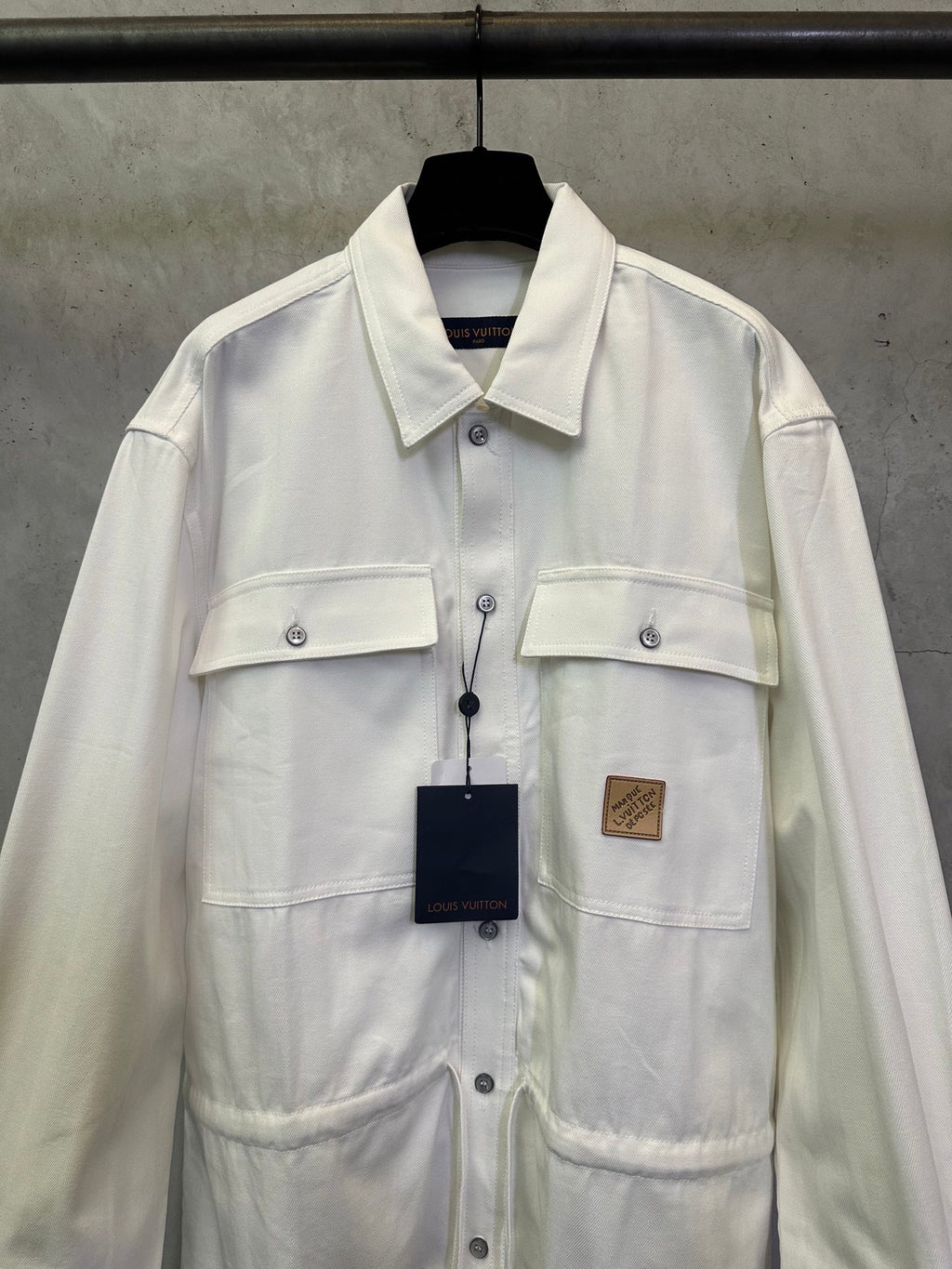 White long-sleeve button-up jacket with chest pockets and button placket