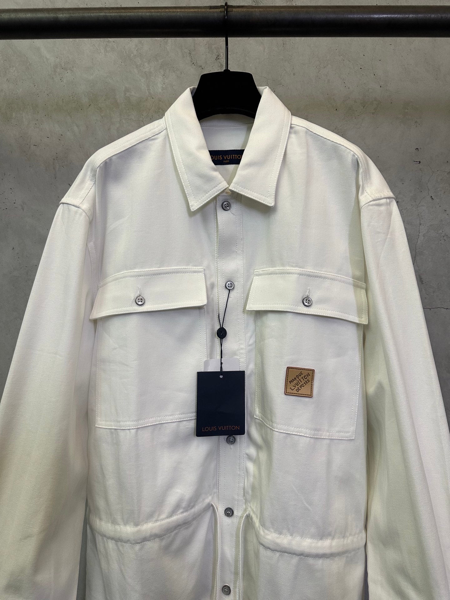 White long-sleeve button-up jacket with chest pockets and button placket