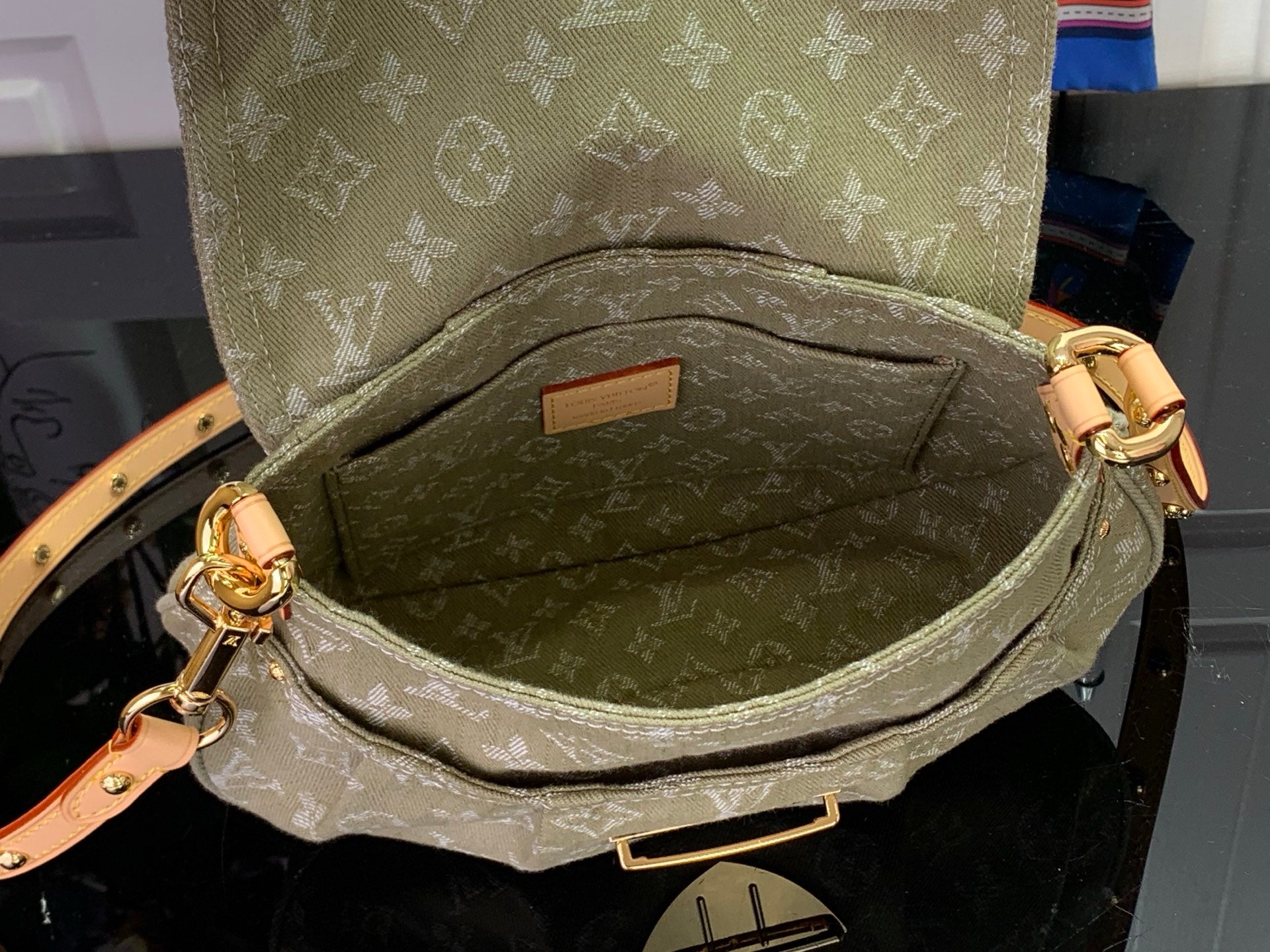 Monogram handbag interior view with zipper pocket and gold pull, tan lining