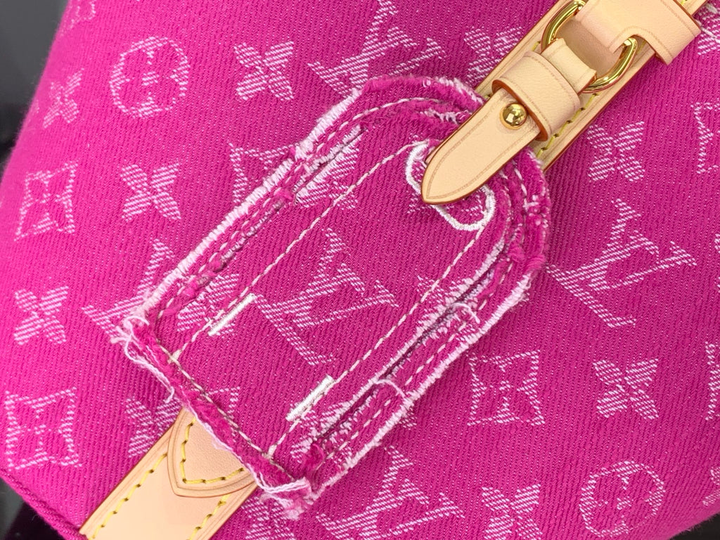 Magenta monogram tote corner with white stitching and tan leather strap detail